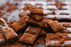 Close up view of cocoa powder and chocolate on dark background