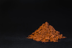 Close up view of cocoa powder on black background with copy space