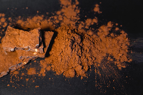 Top view of chocolate and cocoa powder on black surface