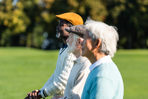 side view of senior man near interracial friends