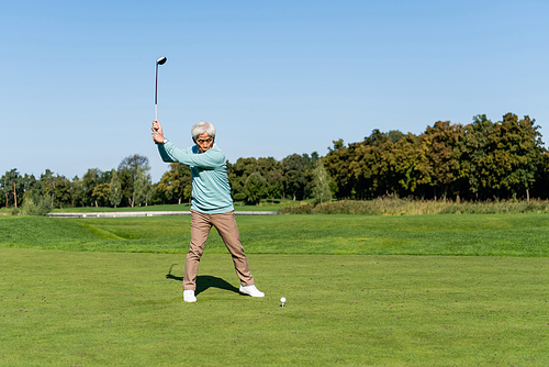 full length of asian senior man playing golf