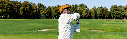 middle aged african american man in flat cap playing golf, banner