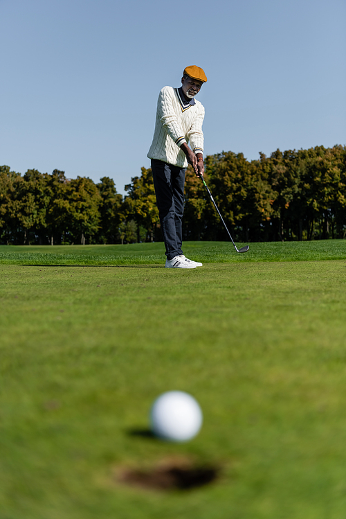 african american man playing golf on green field