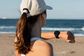back view of brunette woman in  checking fitness tracker