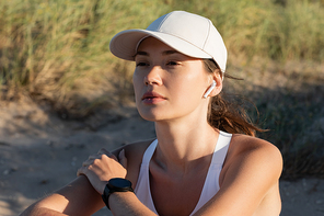 Burnette sportswoman in  listening music in wireless earphone on beach