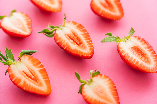 Close up view of cut strawberries on pink background