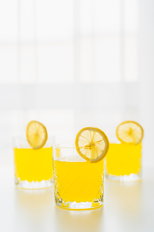 glasses with refreshing citrus tonic and slices of lemon on white background with copy space