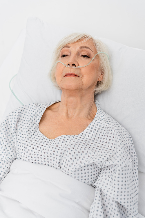 Elderly patient with nasal cannula lying on hospital bed