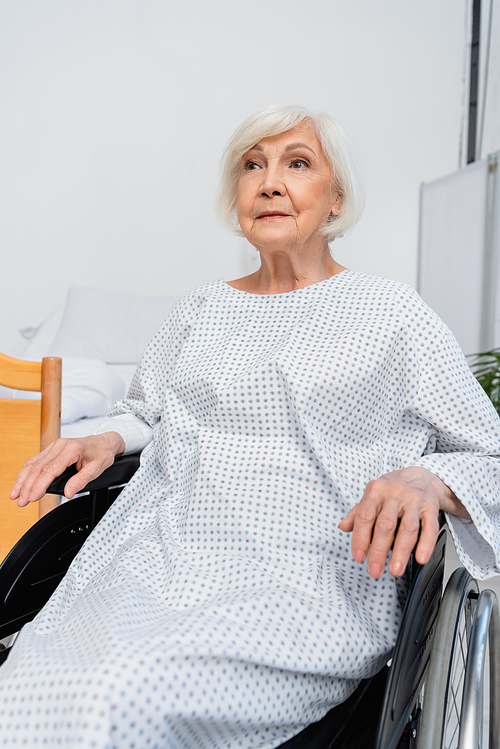 Elderly patient sitting in wheelchair in hospital ward