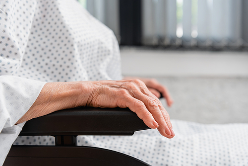 Cropped view of senior woman wearing patient gown in wheelchair