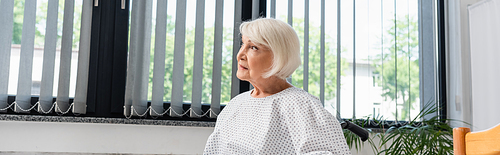 Elderly woman looking away in hospital ward, banner