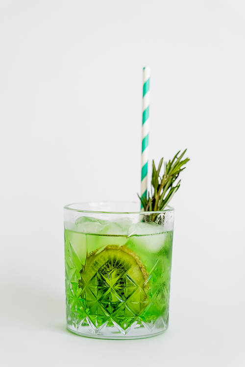 cool faceted glass with kiwi mojito, ice cubes and rosemary isolated on white
