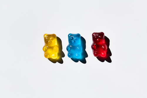Top view of colorful gummy bears on white background