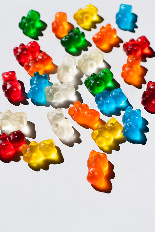 Top view of sweet and colorful gummy bears on white background