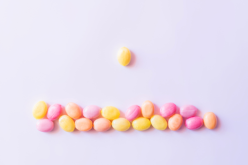 Top view of candy near colorful sweets on white background