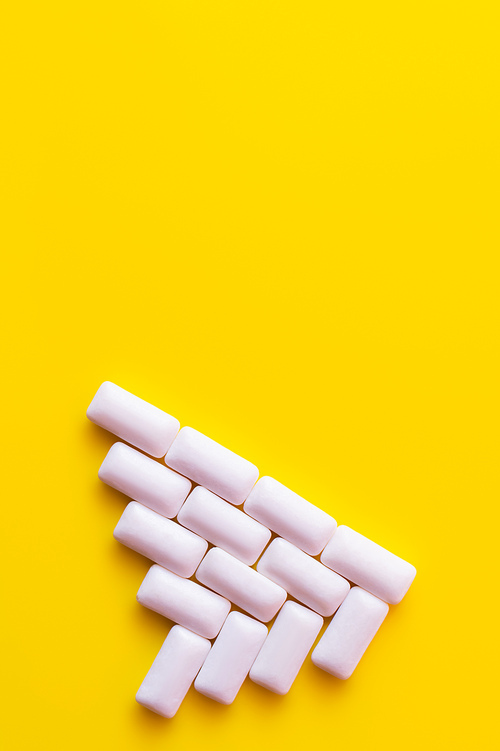 Flat lay with chewing gums on yellow background with copy space