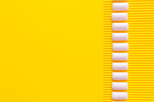 Flat lay with chewing gums on textured yellow background