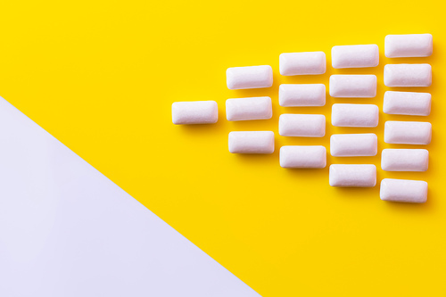 Flat lay with chewing gums on yellow and white surface