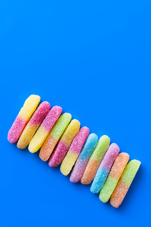 Flat lay with gummy sweets on blue background