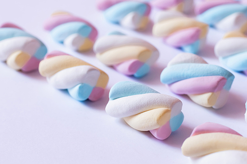 Close up view of colorful marshmallows on white surface