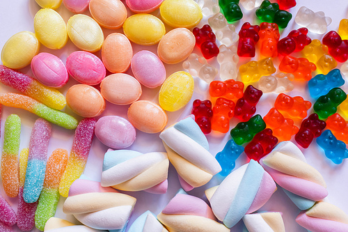 Top view of jelly sweets and marshmallows on white background