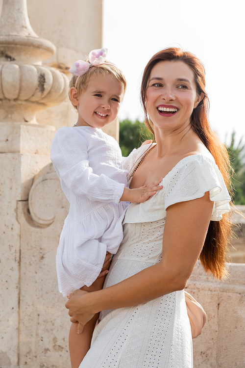 Portrait of smiling mother holding toddler daughter in Valencia