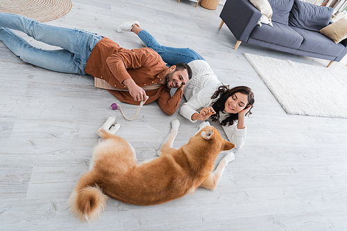 young couple lying of floor with akita inu dog