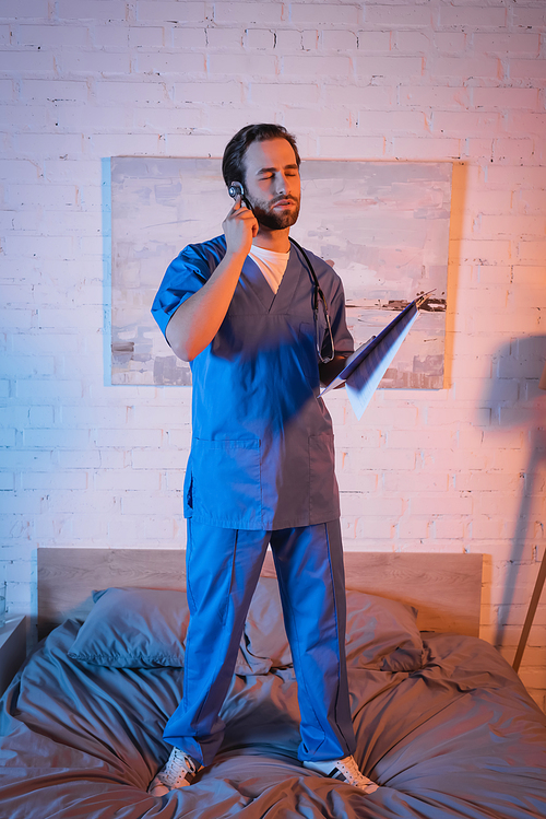 Sleepwalker in doctor uniform holding stethoscope and clipboard on bed