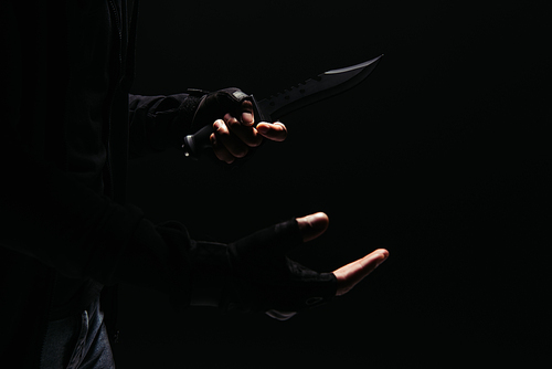 Cropped view of african american bandit in gloves holding knife isolated on black