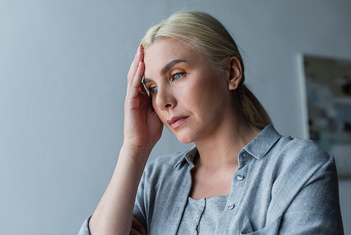 depressed woman with menopause touching forehead and looking away