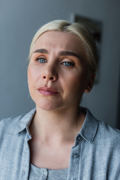 portrait of upset woman with blue eyes feel worried because of menopause