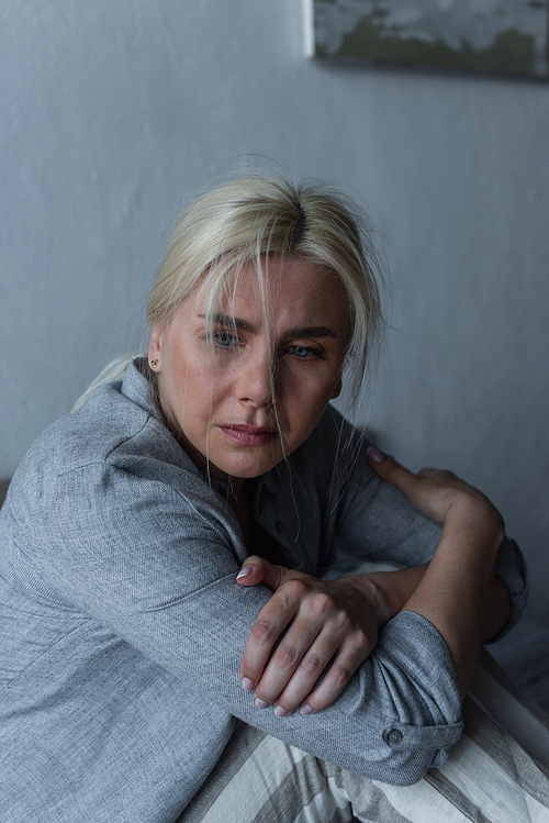 blonde and depressed woman with blue eyes feeling unwell during menopause