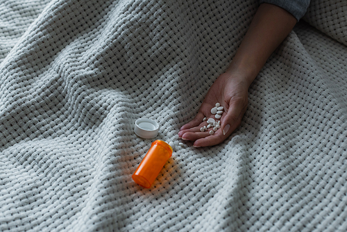 cropped view of depressed woman with climax holding pills in hand