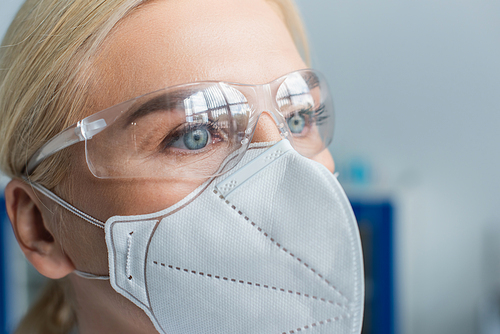 Portrait of scientist in protective mask and goggles in laboratory