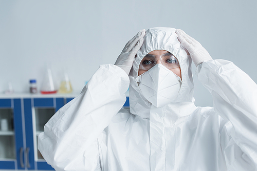 Scientist in hazmat suit and protective mask in laboratory