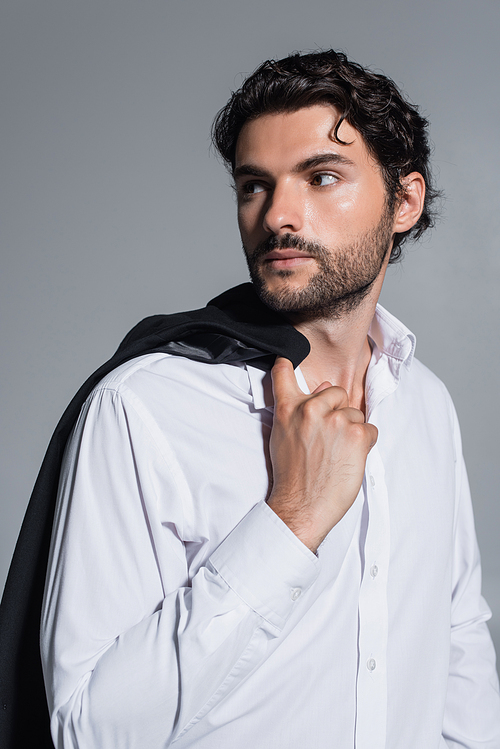 brunette man in white shirt looking away isolated on grey