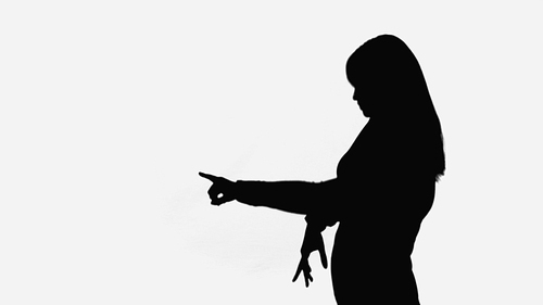 black shadow of woman pointing with finger isolated on white