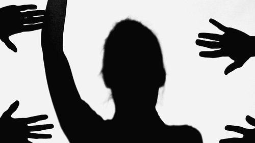 silhouette of woman with arm up near hands of people isolated on white