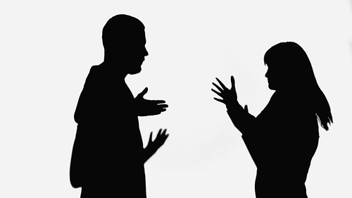 silhouettes of man and woman quarreling and gesturing isolated on white