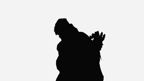 black silhouette of man embracing woman holding flowers isolated on white