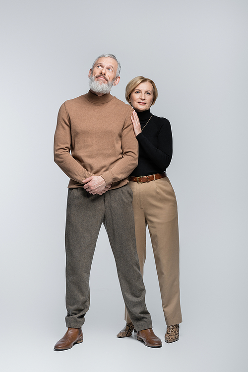 Full length of stylish mature couple posing on grey background