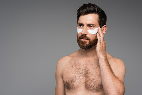 shirtless and bearded man with moisturizing eye patches isolated on grey