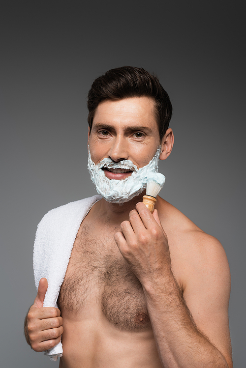 cheerful man applying white shaving foam on face and smiling isolated on grey