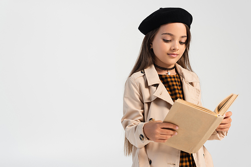 cute girl in stylish autumnal outfit and beret reading book isolated on grey