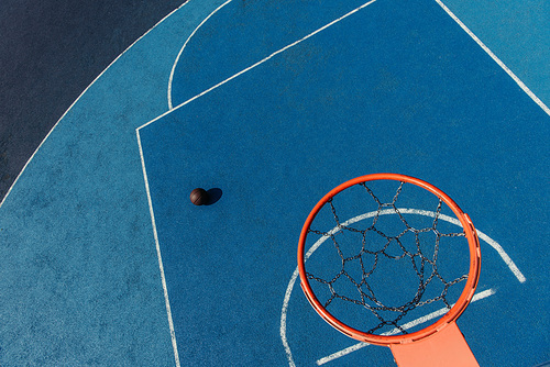 top view of basketball ring over ball on modern outdoor court