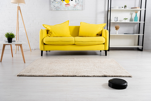 Interior of living room with robotic vacuum cleaner on floor