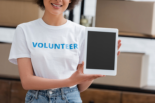 cropped view of african american volunteer holding digital tablet with blank screen in donation center