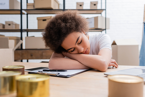 exhausted african american woman sleeping at workplace in volunteer center