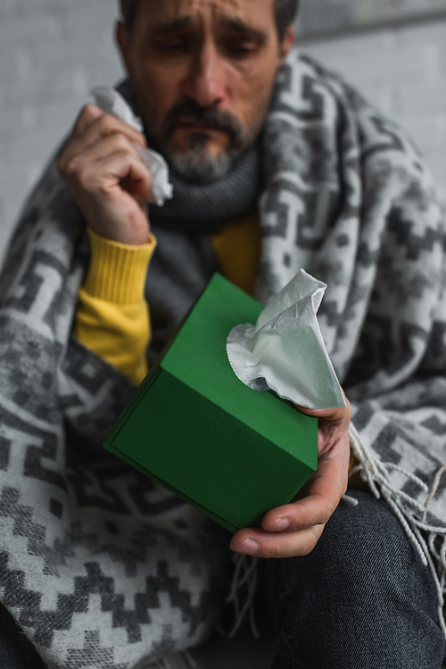 selective focus of pack with paper napkins in hand of diseased man on blurred background