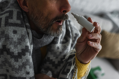 cropped view of sick man with rhinitis using nasal spray